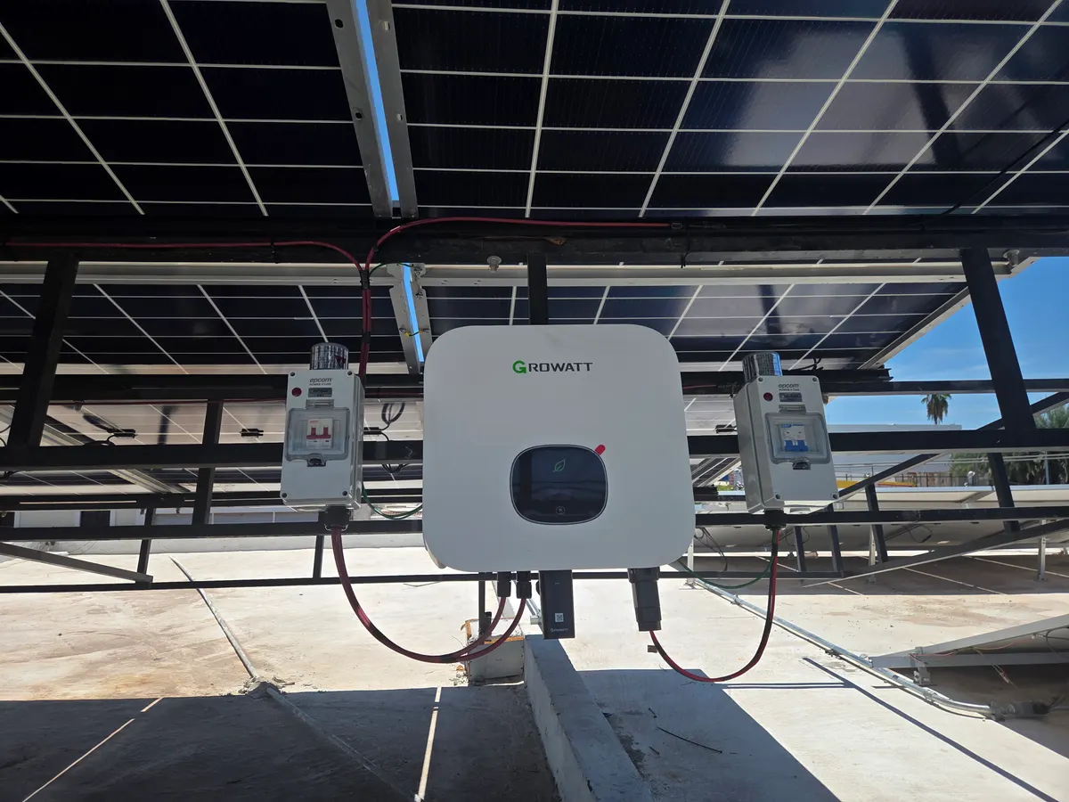 Inversor Growatt con desconectores de corriente directa y alterna instalado bajo un techo solar
